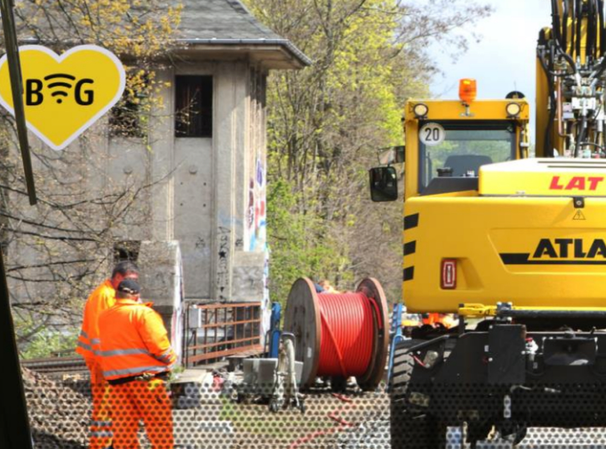 LAT aktuell - Baustelle mit LAT-Mitarbeitern, Kabeltrommel und Schienenbagger