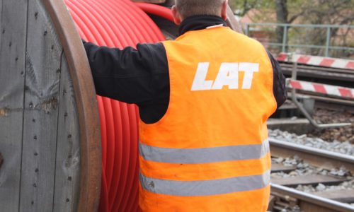 LAT-Mitarbeiter mit Sicherheitsweste an einer Starkstrom-Kabeltrommel bei Gleisbauarbeiten